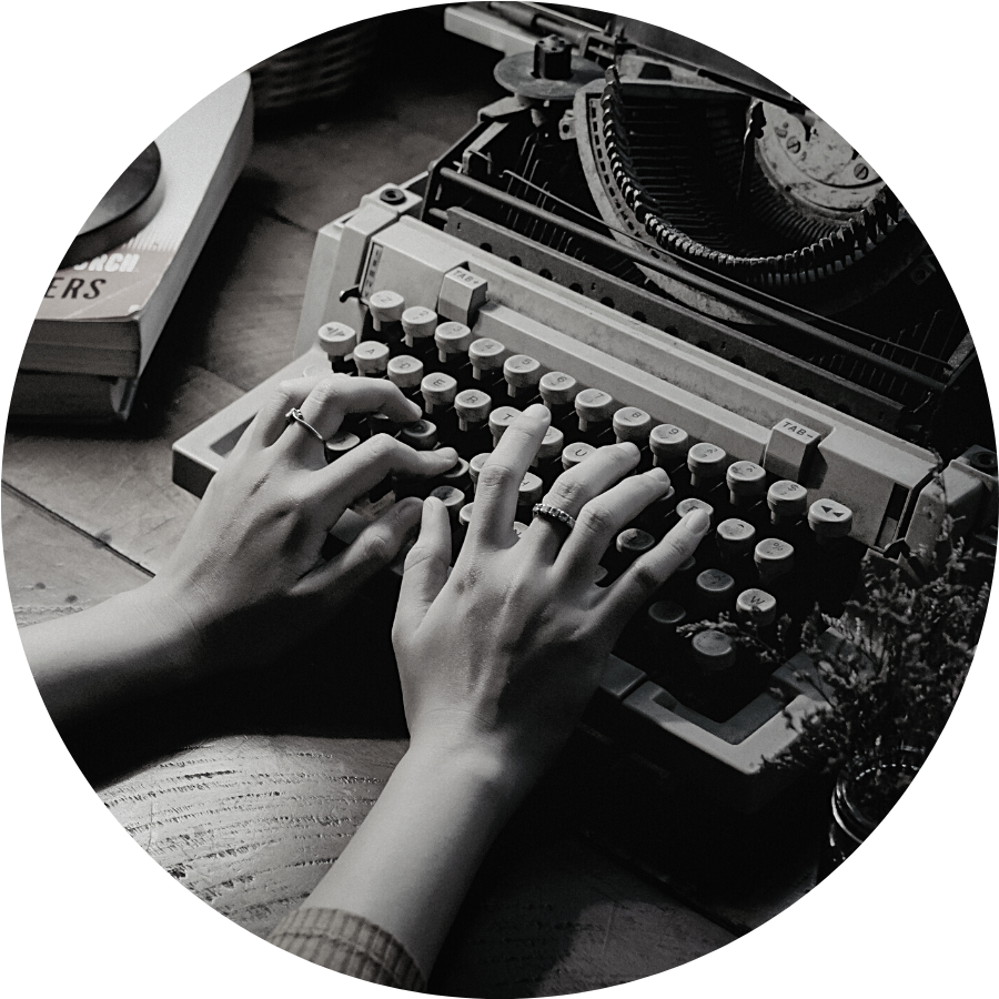 A black and white image of hands typing on a typewriter.